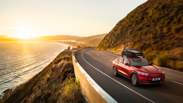 Mach E driving on an ocean-front highway.
